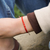 PULSERA TELAR DELGADA ROJA 3 BOLITAS PLATA TEEN